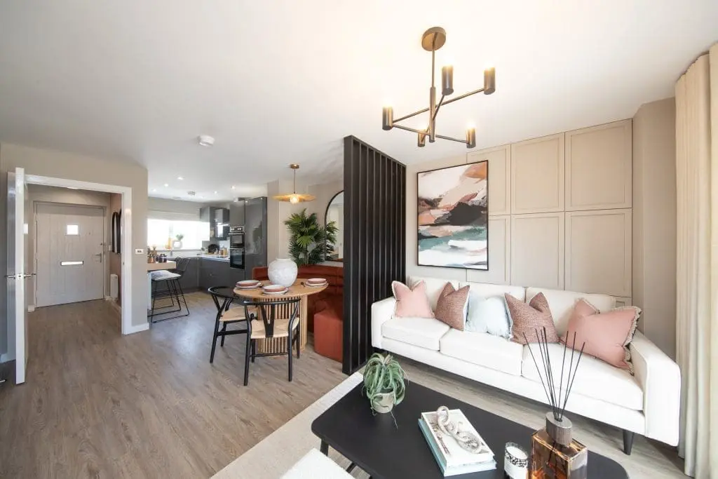 A look at the fully furnished open plan living room interior with the kitchen in the background at Brook View.